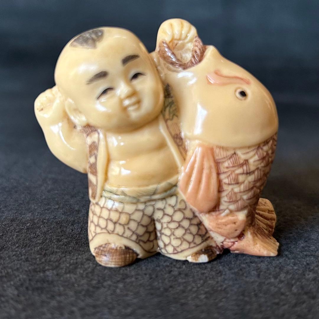 根付　魚を持つ子供の彫刻