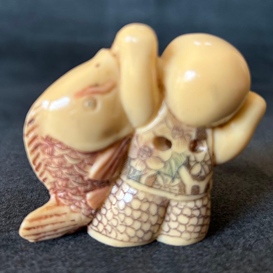 根付　魚を持つ子供の彫刻